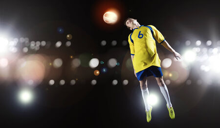 Young football player on stadium kicking ballの写真素材