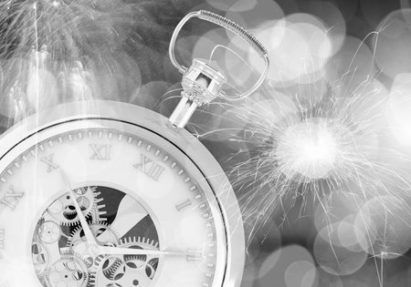 Conceptual image of clock with bokeh lights and firework
