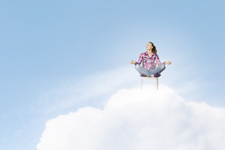 Young woman sitting on chair and meditatingの写真素材