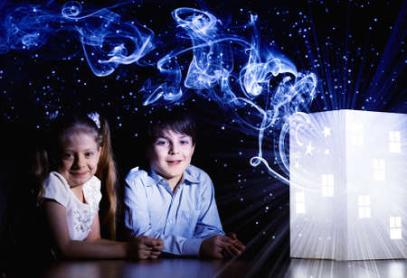 Cute little boy and girl looking at model of houseの写真素材