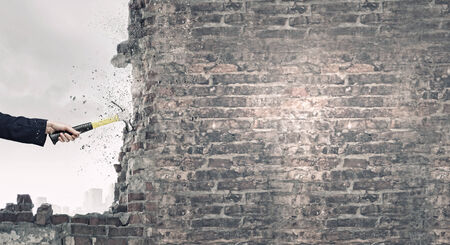 Close up of female hand crashing wall with hammerの写真素材