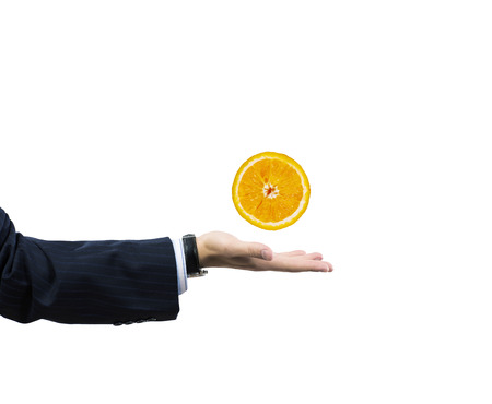 Businessman hand holding juicy orange in palmの写真素材