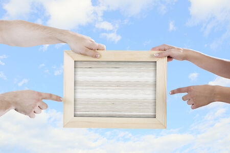 Close up of hands holding wooden blank frame  Place for textの写真素材
