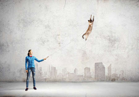 Young woman in casual and cat on leashの写真素材