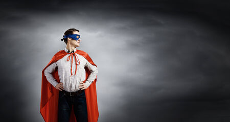 Young confident superhero in mask and capeの写真素材