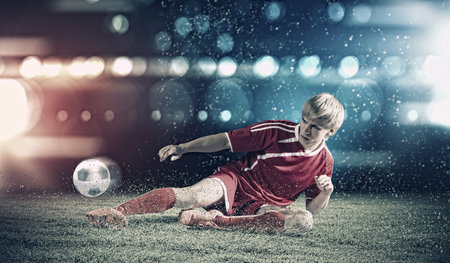 Young football player on stadium kicking ballの写真素材