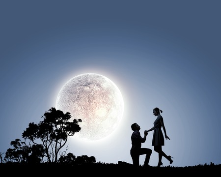 Silhouettes of man making proposal to womanの写真素材