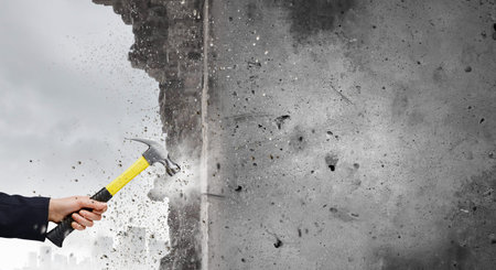 Close up of businessman hand crashing brick wallの写真素材