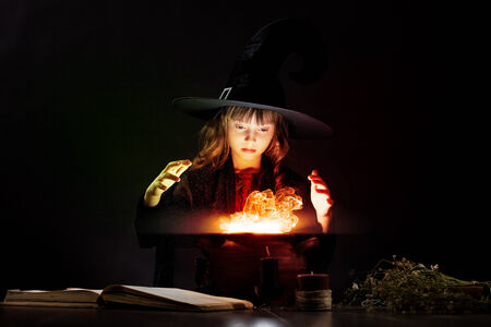 Little Halloween witch reading conjure above potの写真素材