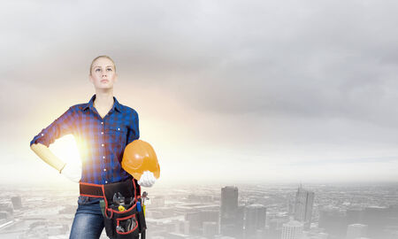 Young pretty woman engineer with tool belt on waistの写真素材