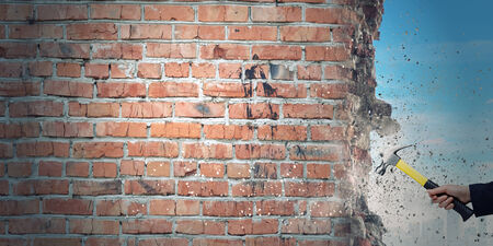 Close up of businessman hand crashing brick wallの写真素材