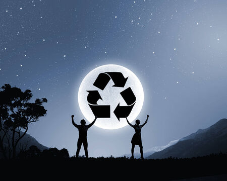 Silhouettes of young couple against full moonの写真素材