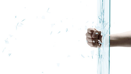 Close up of male fist breaking glass with punch