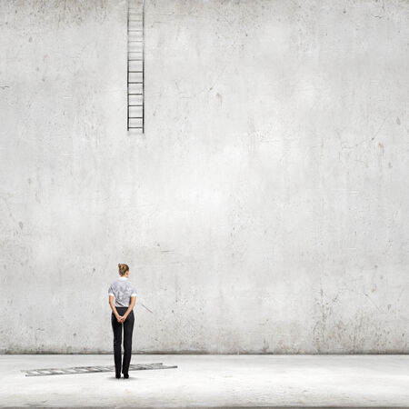 Rear view of businesswoman looking at broken ladderの写真素材