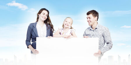 Young happy family with white blank banner  Place for textの写真素材