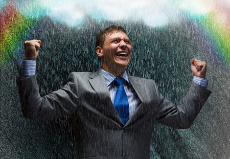 Cheerful businessman with hands up celebrating successの写真素材
