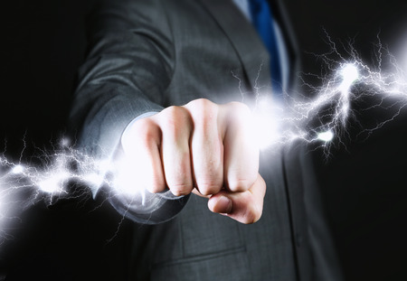 Close up of businessman hand holding lightning in fistの写真素材