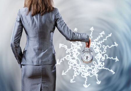 Rear view of businesswoman holding old alarm clockの写真素材