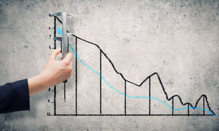 Close up of female hand measuring graph with ruler