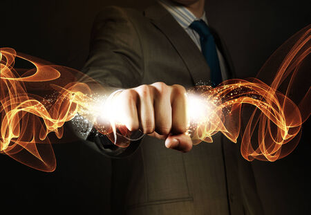 Close up of businessman hand holding light ray in fistの写真素材