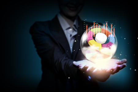 Close up of businesswoman holding bubble with graphs in handの写真素材