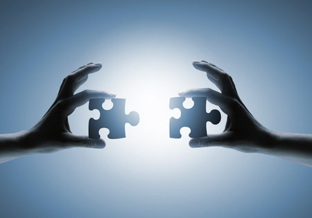 Close up image of hands connecting puzzle elements
