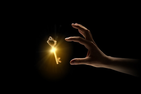 Close up image of business person holding shining keyの写真素材
