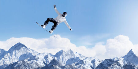 Snowboarder making high jump in clear blue skyの写真素材