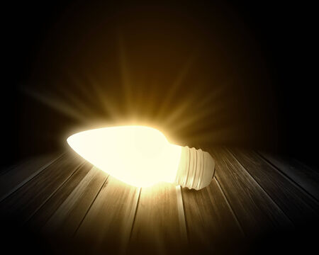 Conceptual image with light bulb and wooden surfaceの写真素材