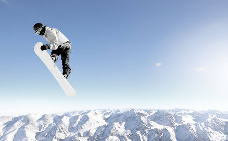 Snowboarder making high jump in clear blue skyの写真素材