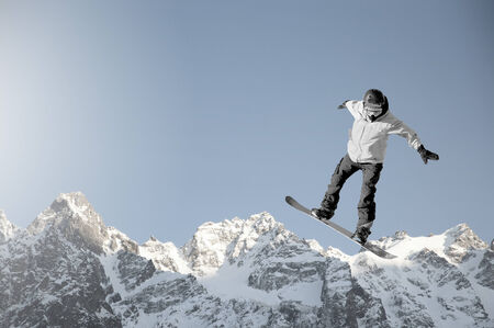 Snowboarder making high jump in clear blue skyの写真素材