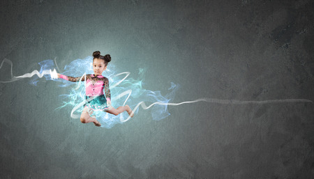 Little cute girl gymnast making high jumpの写真素材