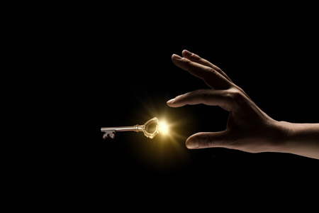 Close up image of business person holding shining keyの写真素材