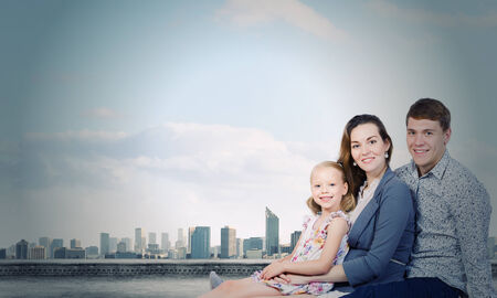 Happy family of three lying on green grassの写真素材