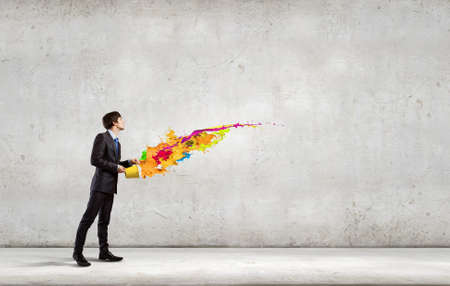 Young businessman holding in hands yellow bucketの写真素材