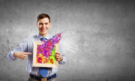 Unrecognizable businessman holding wooden frame with splashesの写真素材