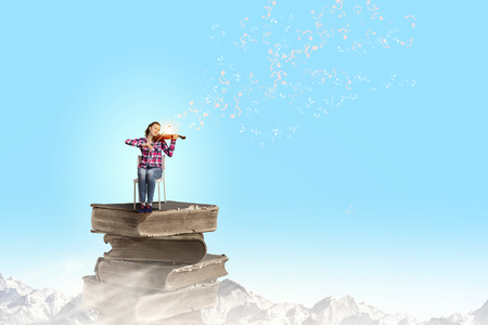 Young pretty girl in casual playing violinの写真素材