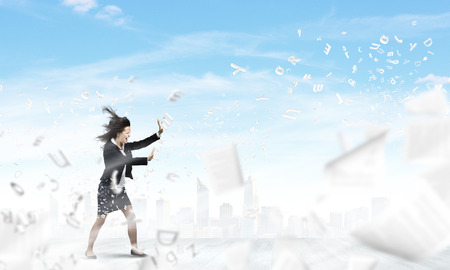 Young determined businesswoman walking against strong windの写真素材