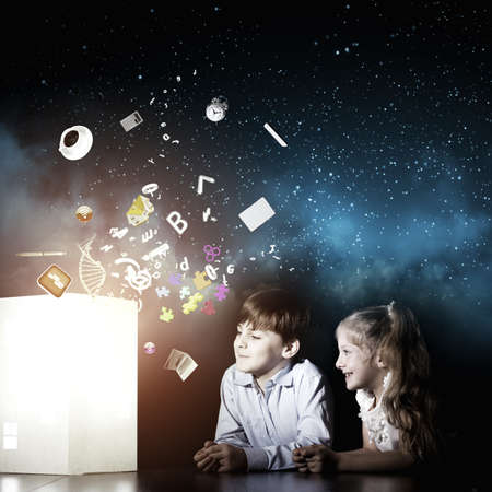 Cute little boy and girl looking at model of houseの写真素材