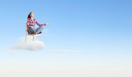 Young woman sitting on chair and meditatingの写真素材