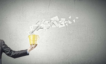 Close up of businessman holding yellow bucket in handの写真素材