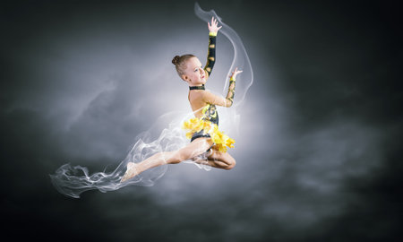 Little cute girl gymnast making high jumpの写真素材