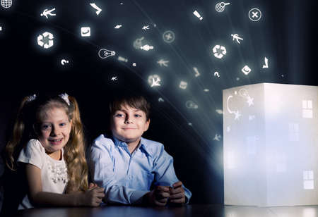 Cute little boy and girl looking at model of houseの写真素材