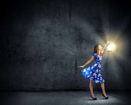 Young woman in blue dress with lanternの写真素材