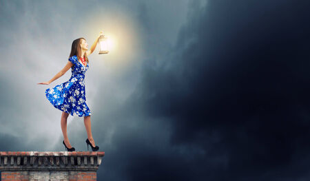 Young woman in blue dress with lanternの写真素材