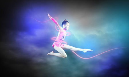 Little cute girl gymnast making high jumpの写真素材