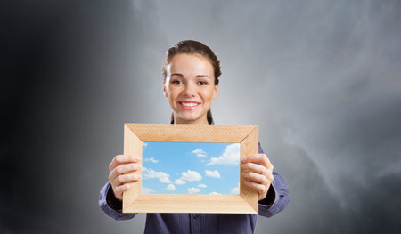 Young woman in shirt with wooden frame in hands