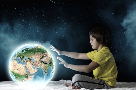 Cute boy sitting in bed and dreaming.  の写真素材