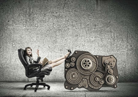 Young attractive businesswoman reading book in chairの写真素材