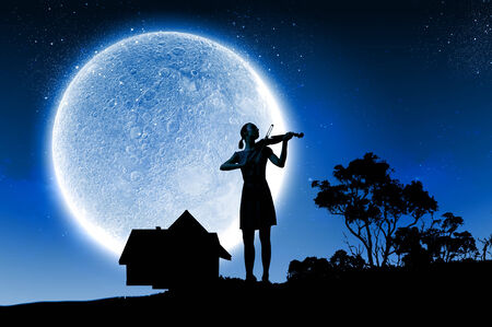 Silhouette of woman playing violin at nightの写真素材